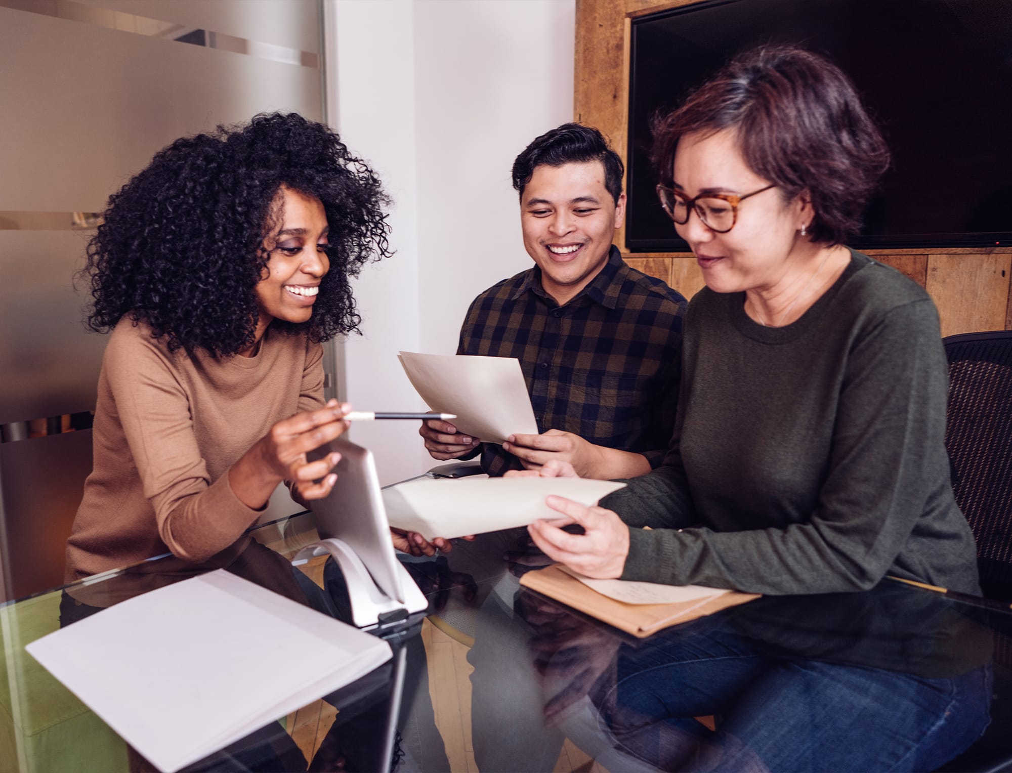 a group of people sitting at a table using a laptop